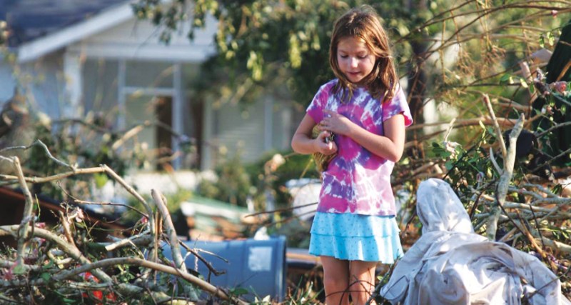 girl standing in wreckage of Hurricane Katrina