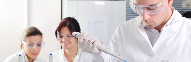 male scientist in foreground, two women scientists in background