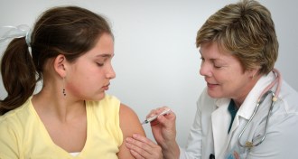 woman giving young girl a vaccination