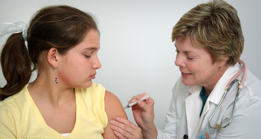 woman giving young girl a vaccination