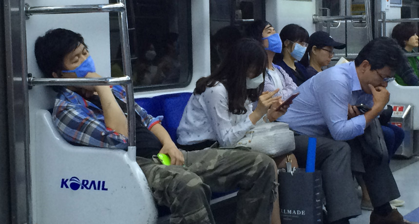 people wearing surgical masks on subway in Seoul, South Korea
