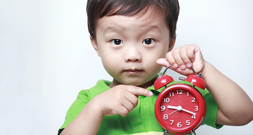 toddler holding alarm clock