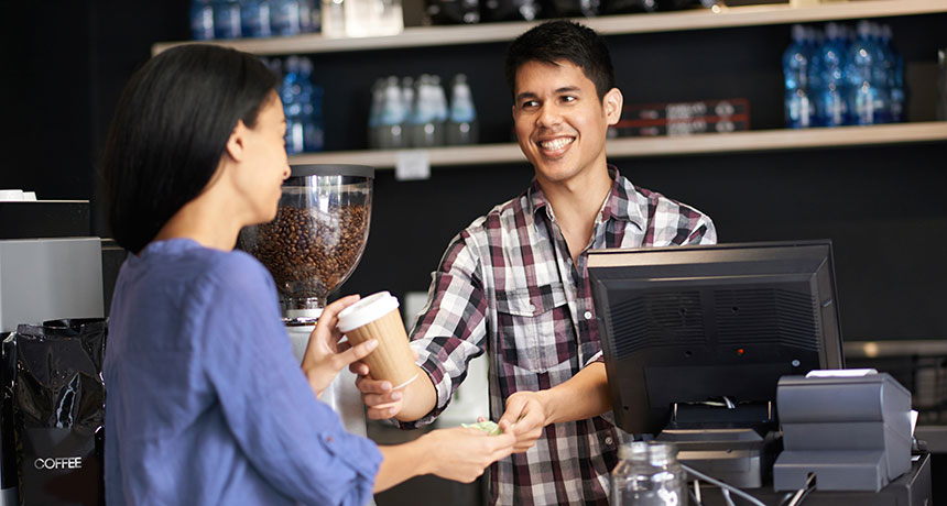 man behind counter serving coffee