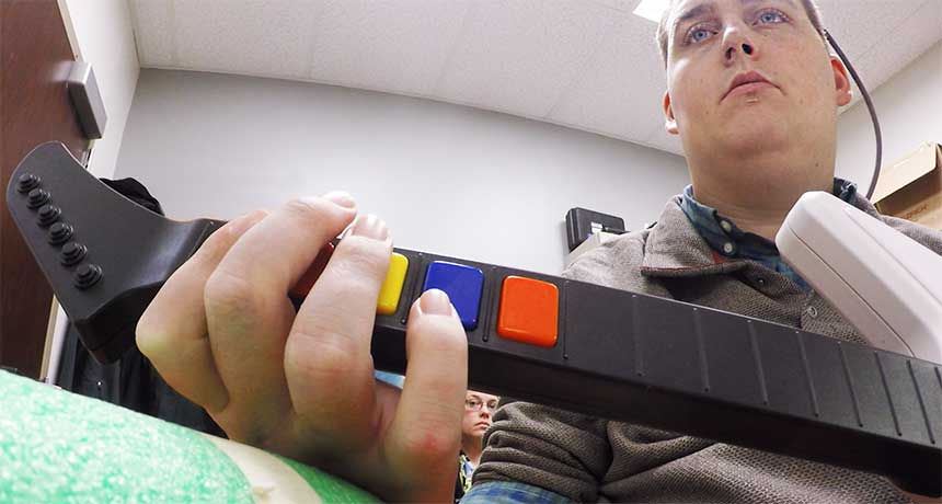 a paralyzed man playing a guitar video game