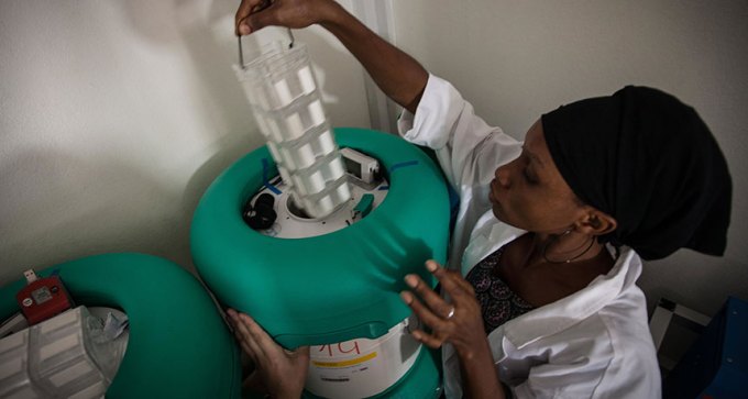 woman putting ebola vaccine into canister