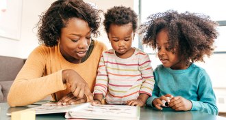 parent reading to two kids