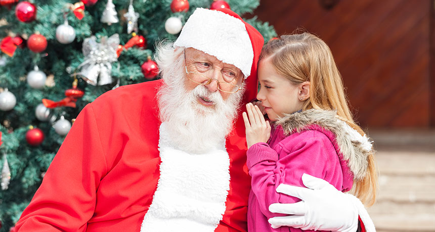 little girl whispering in Santa's ear