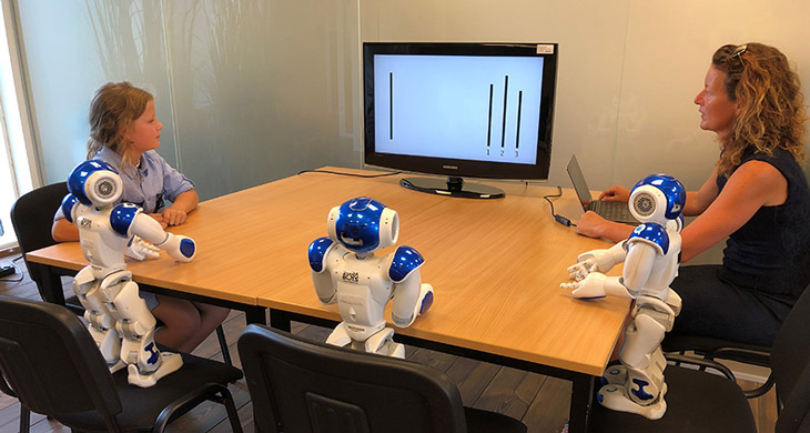 child with three robots and an adult