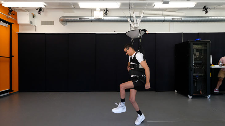 A photo of David Mzee learning to walk using a harness supporting his body weight