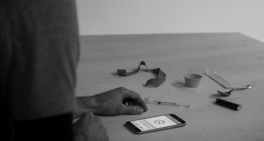 person looking at a phone with drug paraphernalia