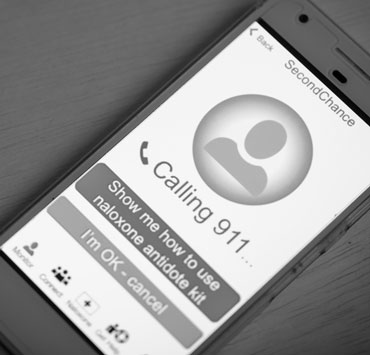an illustration of the SecondChance app on a phone. text reads "calling 911... " one button says "Show me how to use nalaxone antidote kit" and the button below that "I'm OK - cancel"