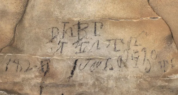 a photo of a Cherokee inscription on the wall of a cave