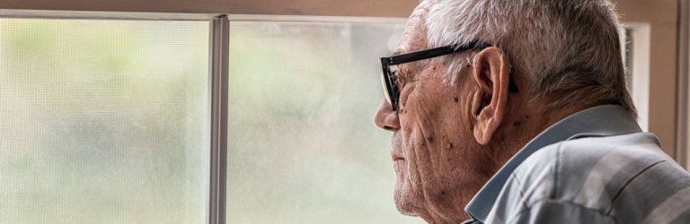 elderly man looking out window