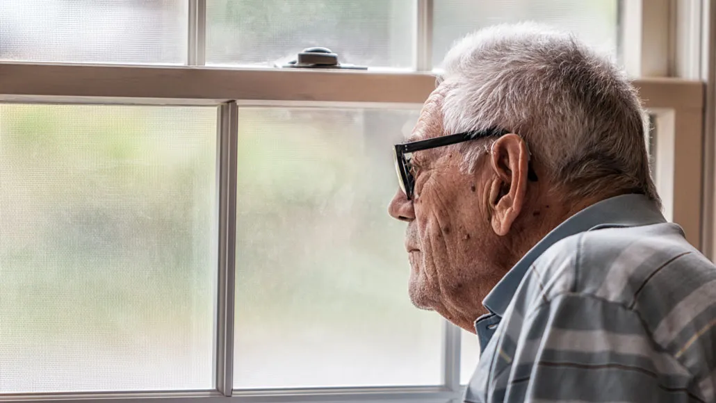 elderly man looking out window