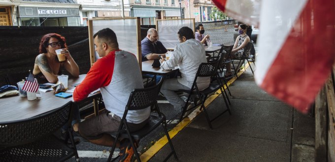 people sitting at distanced tables in a restaurant