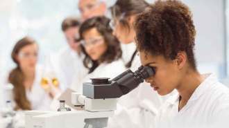 Student looking into a microscope