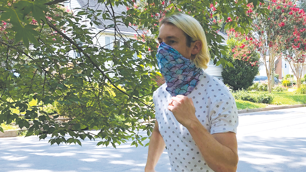 man running while wearing a neck gaiter over his nose and mouth
