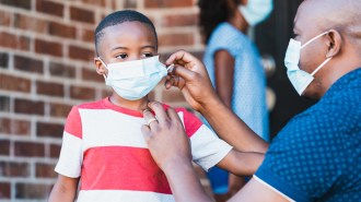 man putting mask on youth