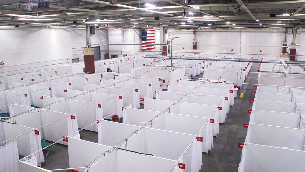 view from above of a huge room filled with curtain partitions and hospital beds
