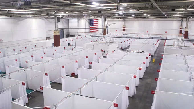 view from above of a huge room filled with curtain partitions and hospital beds