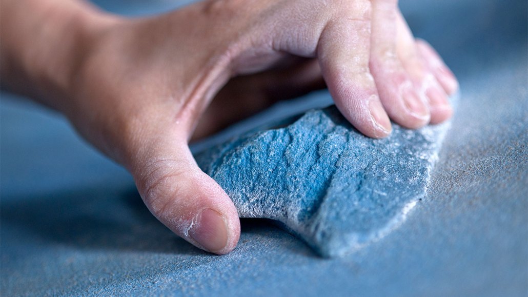 Hand gripping a handhold at a climbing gym