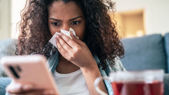 Woman looks at fake health news on her phone