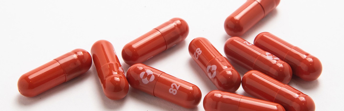 ten reddish molnupiravir pills on a white background