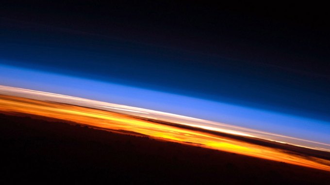 image of Earth's atmosphere with the troposphere visible in orange