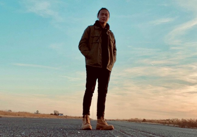 researcher Zehao Wu standing in a road at sunset