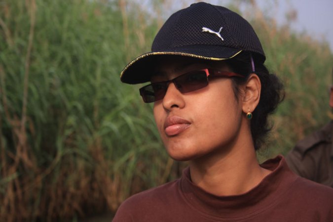 image of Tiasa Adhya wearing ball cap and sunglasses with marsh in the background