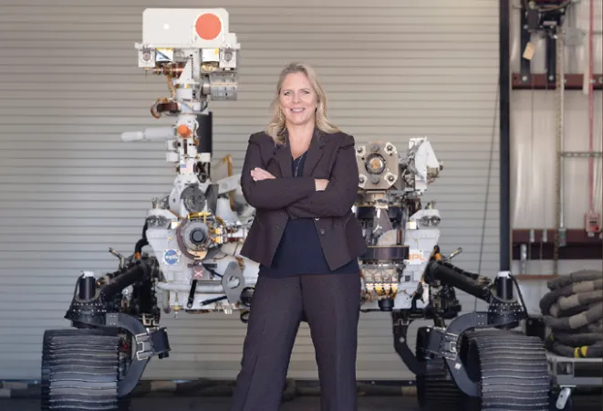 image of Jennifer Trosper standing in front of a model of the Perseverance rover