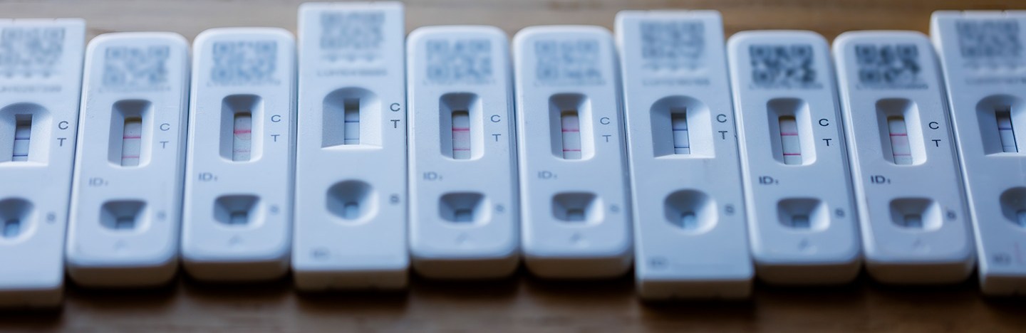A row of 10 positive coronavirus tests on a table