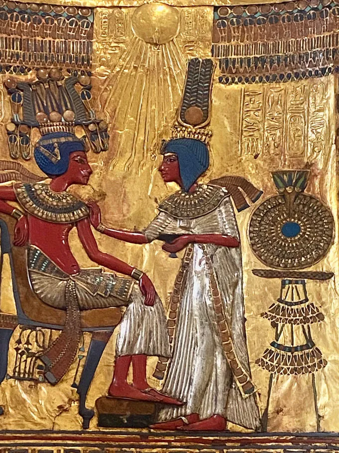 painting of Tutankhamun and his queen on the backrest of his gold throne