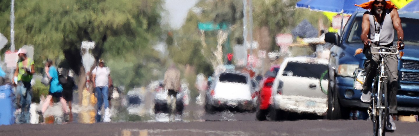 Person riding a bicycle in Phoenix during a period of extreme heat.