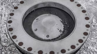 Asteroid rock and dust appears on the outer surface of the circular capsule that collected the asteroid sample.