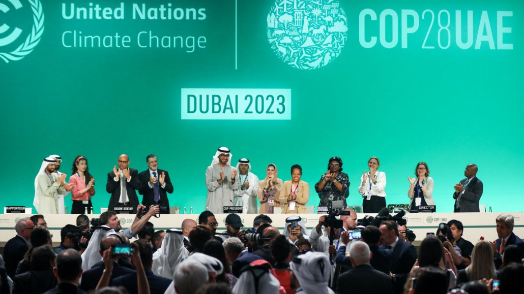 Leaders and attendees at COP28 standing and clapping on the last day of the United Nations climate summit.