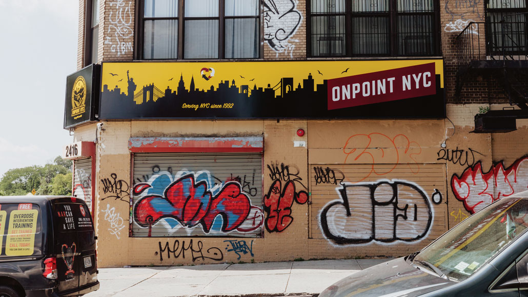 A street corner showing OnPoint in Washington Heights with graffiti on the outside.