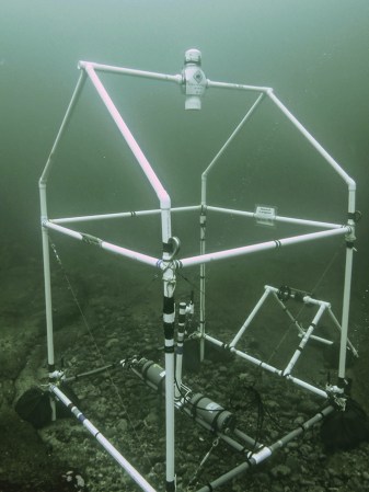 A plastic pipe structure in the shape of a house holds hydrophones and cameras to record creatures on the ocean floor.