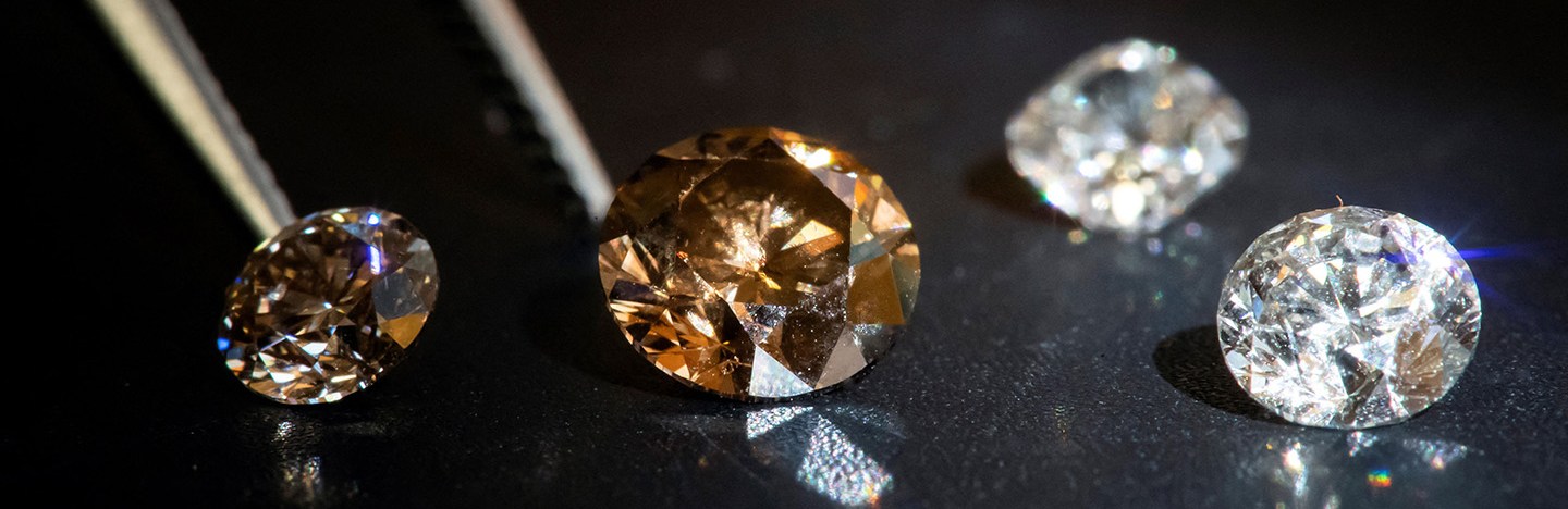 Four diamonds of varying hues are shown on a black background