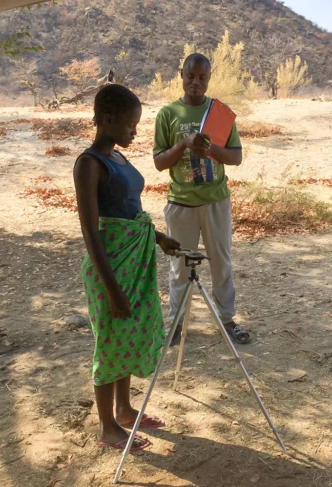 An Ovatwa teenager in Namibia uses a compass to point to an out-of-sight landmark, a measure of navigation ability.