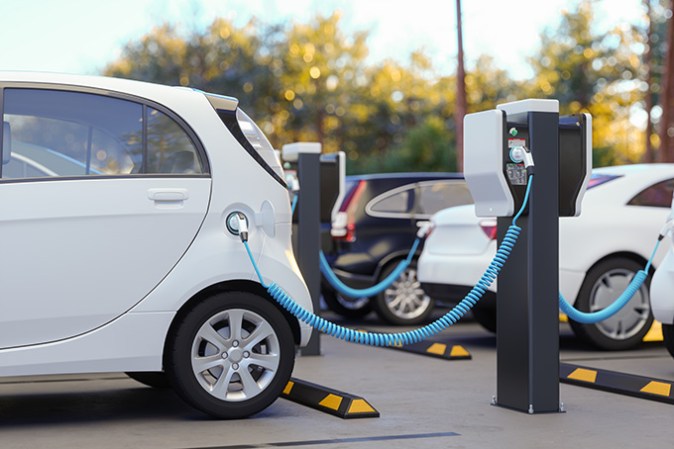 A photograph of an electric vehicle at a charging station.