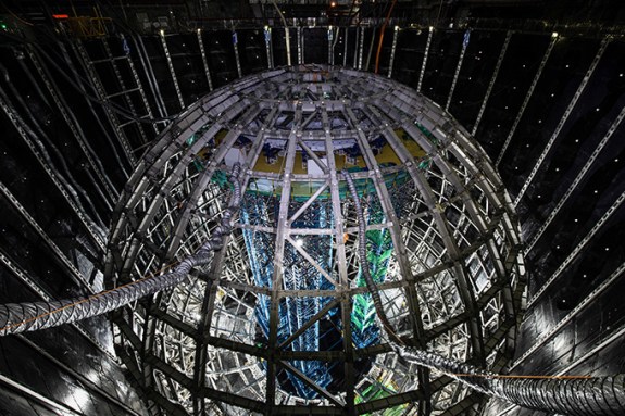 A spherical steel structure is shown inside of a large pit.