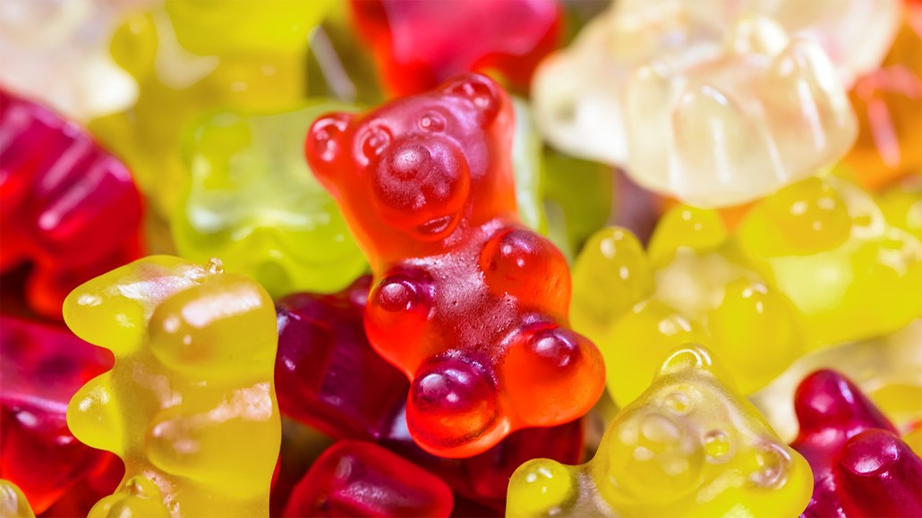 A red gummy bear sits on a jumble of yellow, white and red gummy bears. The red color may be due to Red No. 3, a dye now banned by the FDA.