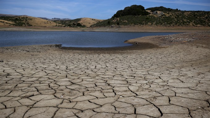 Dry, cracked earth rings a depleted reservoir in California after many years of drought.