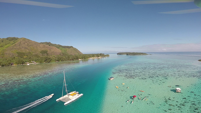 A few boats sit in shallow water near a shoreline