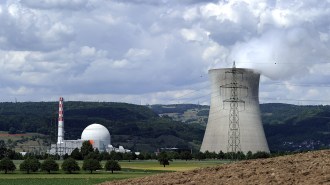 A nuclear reactor, associated buildings and a cooling tower of the Leibstadt Nuclear Power Plant are shown beneath a cloudy sky