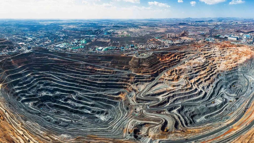 An open pit mine in China. A city can be seen in the background.