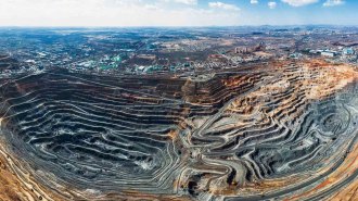 An open pit mine in China. A city can be seen in the background.