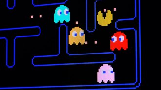 Pac-Man on a black video game screen surrounded by colorful ghosts.