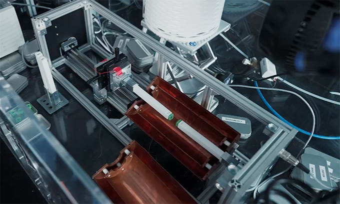 An experimental apparatus with two green squares mounted on arms about to touch.